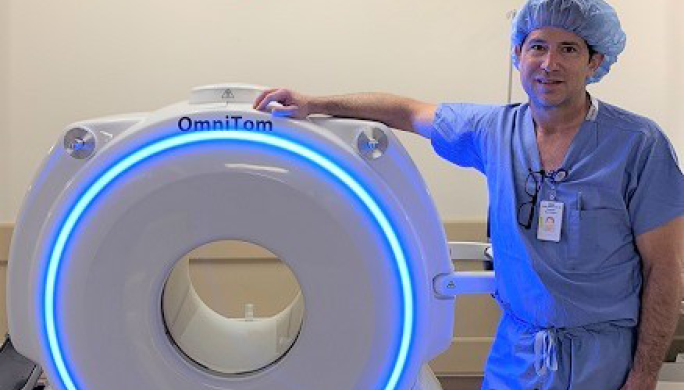 Dr. VanSickle stands with the OmniTom machine