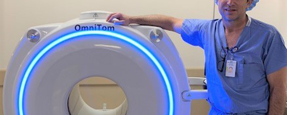 Dr. VanSickle stands with the OmniTom machine